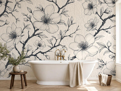 Ink cherry blossom branches on ivory behind a freestanding white bathtub, with a wooden stool and a vase of greenery