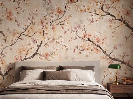 Watercolour cherry blossom wallpaper in blush and ivory behind an upholstered bed with linen bedding