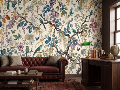 The same garden mural behind a burgundy chesterfield sofa, beside a wooden desk with a green banker's lamp