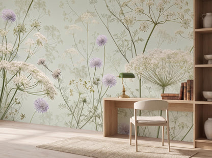 Close view of the cream umbels and lilac pom-pom blossoms above a pale desk