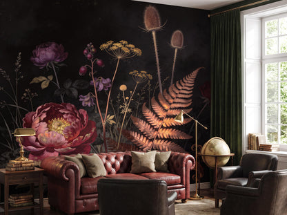 Dark botanical wallpaper beside a bright window, with an oxblood chesterfield and a brass lamp