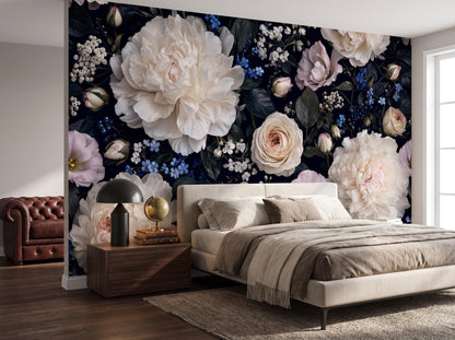 The dark peony wallpaper across a bedroom wall, with a linen bed and an oxblood chesterfield