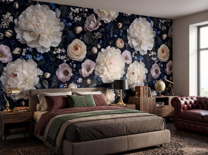 Close view of the peonies, roses and blue forget-me-nots above a bed and bedside lamp