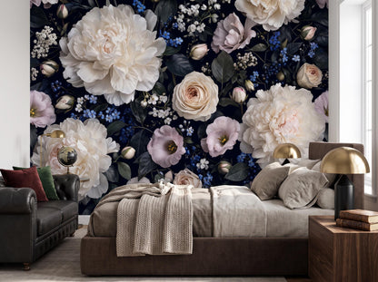 Bedroom corner with the deep blue floral wallpaper, a bed with a cream throw and a brass lamp