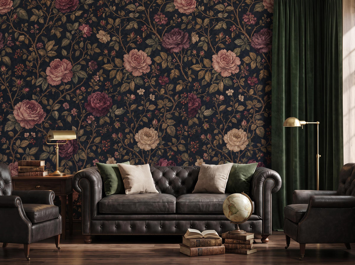 Dark rose floral wallpaper on a midnight ground behind a tufted sofa, brass lamp and globe