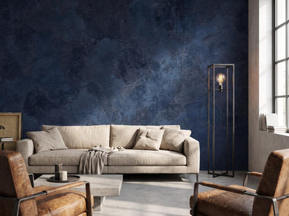 Navy blue plaster wall mural behind a linen sofa, with leather armchairs and a concrete coffee table