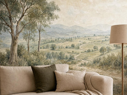 Close view of the trees, fields and distant hills in the countryside mural, above a cream sofa