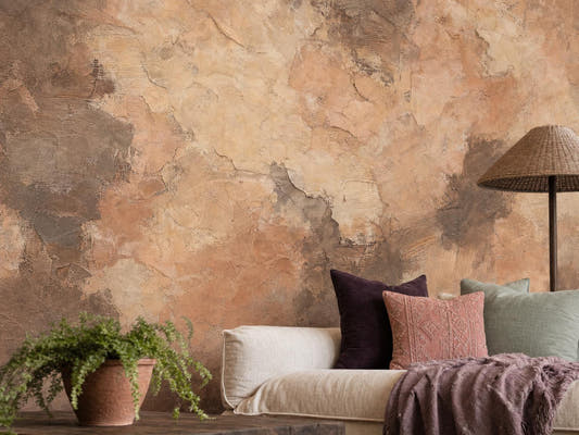 Close view of the dark brown limewash wall, with scraped clay and cocoa passages, beside a linen sofa with plum