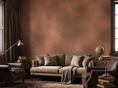 Warm rust limewash wall behind a linen sofa, leather armchair, brass lamp and globe