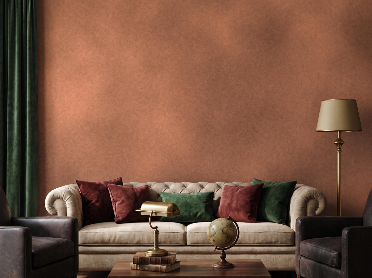 The terracotta limewash wall across a room, with a tufted sofa, jewel cushions and a floor lamp